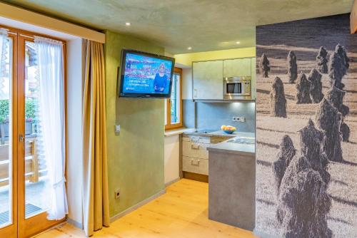 a kitchen with a television on a wall with a mural at Ferienwohnung Ferienglück in Krün