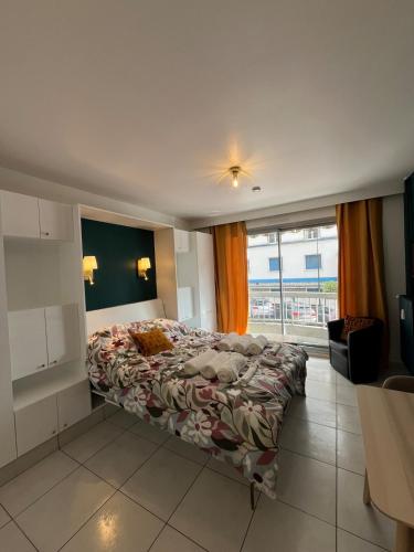 une chambre avec un lit et une grande fenêtre dans l'établissement Magnifique appartement renové le Victoria, à Aix-les-Bains