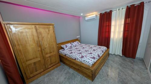 a small bedroom with a bed and curtains at City delight in Kpéti
