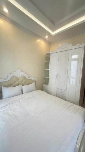 a bedroom with a white bed and a white cabinet at BiBo-House-89-PHT in Xuan An