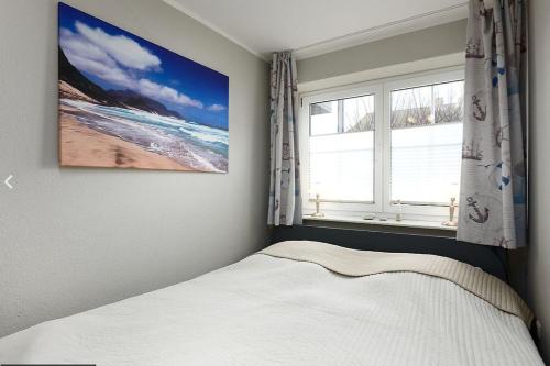 a bedroom with a bed and a picture on the wall at Ostseemuschel Laboe in Laboe