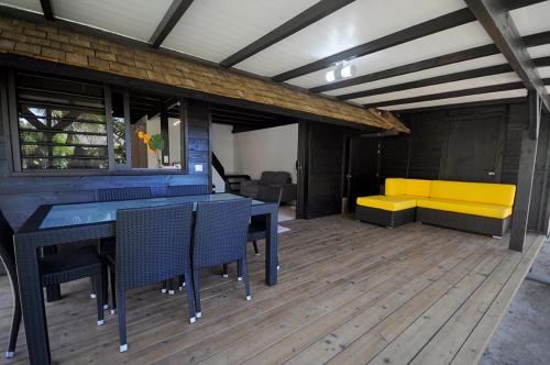 a room with a table and chairs and a yellow bench at Bungalow Moe Moe Moea by ENJOY VILLAS in Motu Tiahura