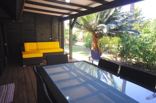a patio with a table and chairs and a pool at Bungalow Moe Moe Moea by ENJOY VILLAS in Motu Tiahura