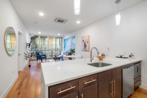 a kitchen with a sink and a living room at Chic 1BR Retreat - Pool, Gym Balcony Views in Philadelphia