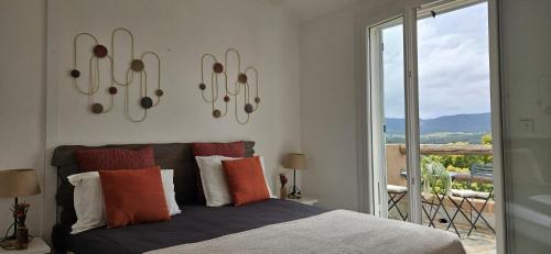 - une chambre avec un lit doté d'oreillers colorés et d'une fenêtre dans l'établissement Mini villa Vue Mer Santa Giulia - Accès plage à pied - 2 à 4 pers - 1 chambre, à Porto-Vecchio