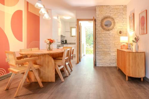 a kitchen and dining room with a wooden table and chairs at Les 15 Pins & La Mer -Your green getaway near sea & beach in Antibes