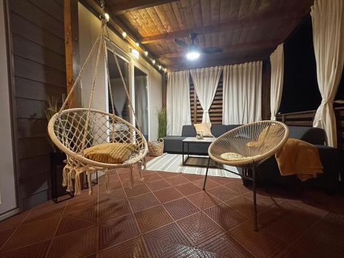 a porch with two chairs and a swing at Mobile home Lea, kamp Soline in Biograd na Moru