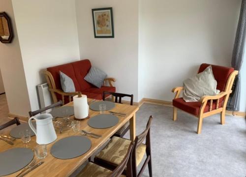 a living room with a wooden table and chairs at Tigh na Mara, Brand New Semi-Detached House, Furbo in Furbo