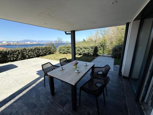 a wooden table and chairs on a patio at MERTIK house in Omišalj