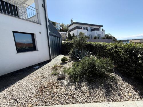 a side walk next to a white building with plants at MERTIK house in Omišalj