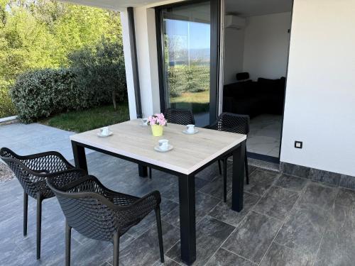 a wooden table and chairs on a patio at MERTIK house in Omišalj