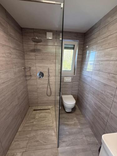 a bathroom with a shower and a toilet at MERTIK house in Omišalj