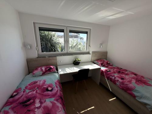 a room with two beds and a desk and a window at MERTIK house in Omišalj
