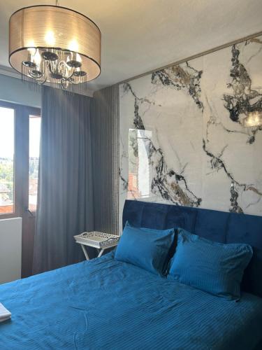 a bedroom with a blue bed with a map on the wall at Didi Park House къща с две спални in Sandanski
