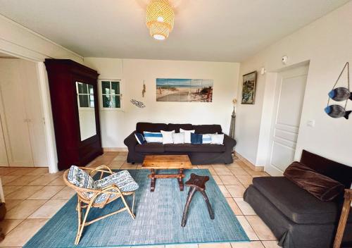 un salon avec un canapé et une table dans l'établissement Gite du Bois de l 'Espie - Beach & Nature, à Étaules