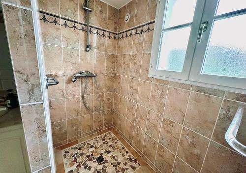 une salle de bain avec une douche avec une porte vitrée dans l'établissement Gite du Bois de l 'Espie - Beach & Nature, à Étaules