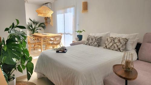 a bedroom with a white bed and a table and chairs at Apartamento Mar de Roquetas in Roquetas de Mar