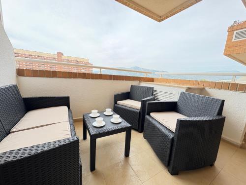 a balcony with two chairs and a table with cups on it at ACV - Torremar-2ª linea planta 3 sur 2 in El Borseral
