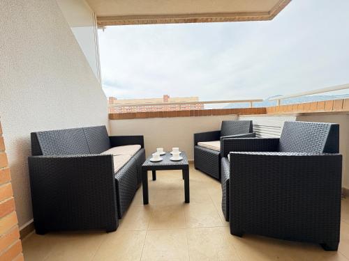 a balcony with two chairs and a table at ACV - Torremar-2ª linea planta 3 sur 2 in El Borseral
