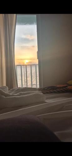 a bedroom with two beds and a window with the sunset at Apartamentos Bahia Rocky Point in Providencia