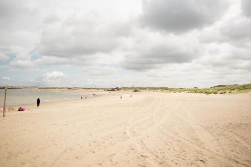 a group of people walking on a sandy beach at Resort Land & Zee in Scharendijke