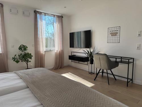 a bedroom with a bed and a desk and a television at Boutique Studio Apartment Lucca - Parkplatz - Bahnhof in Osnabrück