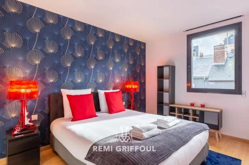 une chambre avec un grand lit avec des oreillers rouges dans l'établissement The Cosmopolitan Architect Design Home with Rooftop Jacuzzi 8 Guests, à Honfleur