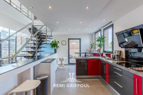 a kitchen with red cabinets and a spiral staircase at The Cosmopolitan Architect Design Home with Rooftop Jacuzzi 8 Guests in Honfleur
