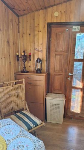 a bedroom with a bed and a wooden wall at Wooden house Ada in Ada Ciganlija