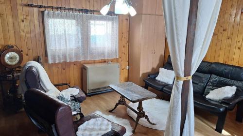 a living room with a couch and chairs and a window at Wooden house Ada in Ada Ciganlija