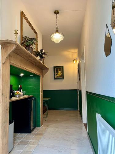 a hallway with green and white walls and a counter at Le Charme du Perigord - chambre & table d'hotes in Saint-Sulpice-dʼExcideuil