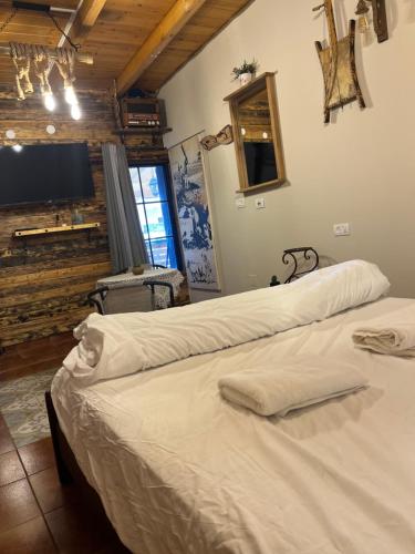 two white beds in a room with a tv at לומינוס הגפן in Ḥurfeish