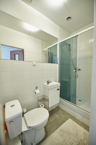 a white bathroom with a toilet and a shower at Apartamenty Grottgera in Rzeszów