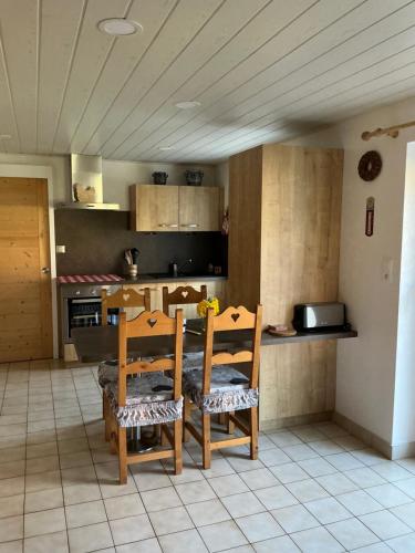 - une cuisine avec une table et deux chaises dans l'établissement LES CŒURS DU TILLEUL, à Gérardmer