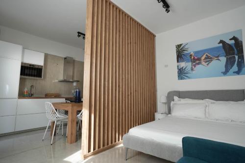 a bedroom with a bed and a kitchen with a table at B&B Casa Casti in Margherita di Savoia