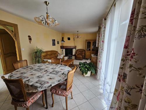 ein Esszimmer mit Tisch und Stühlen und ein Wohnzimmer in der Unterkunft Jolie maison -3 chambres -au calme -proche du lac du der in Rachecourt-sur-Marne
