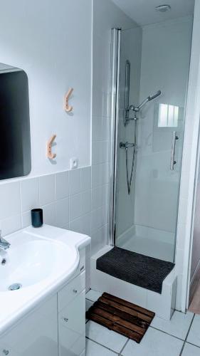 une salle de bain blanche avec une douche et un lavabo dans l'établissement La brulière 4ch, à Velaux