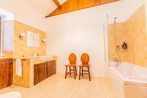 two chairs in a bathroom with a tub and a sink at Solar do Maranhão in Capelas