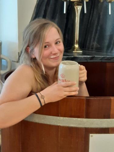 a woman is holding a cup of coffee at Gasthof zur Kirche in Kottes