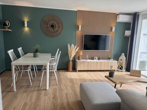 a living room with a table and a television at Marina View Empuriabrava - Appartement sud-ouest au canal avec terrasse in Empuriabrava