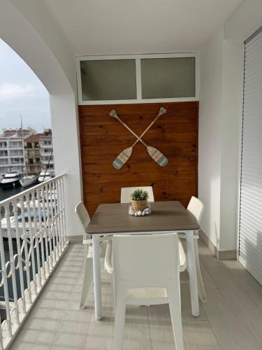 a table and chairs on a balcony with a clock at Marina View Empuriabrava - Appartement sud-ouest au canal avec terrasse in Empuriabrava