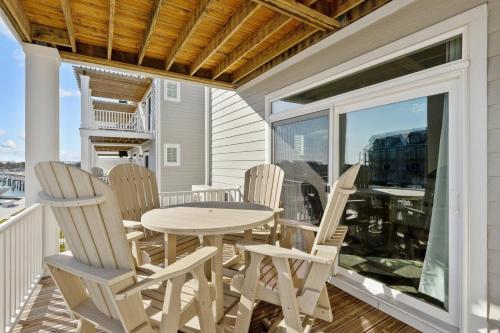a patio with a table and chairs on a balcony at South Breeze townhouse in Beaufort