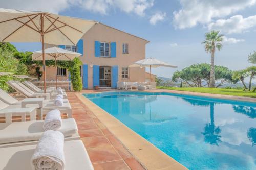 une piscine avec chaises et parasols devant une maison dans l'établissement JAMES FCD06 - charming Croix-Valmer villa with pool and stunning panoramic sea view, à La Croix-Valmer