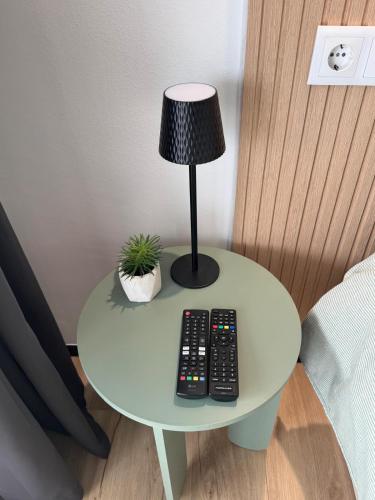 a table with a lamp and two remote controls on it at Marina View Empuriabrava - Appartement sud-ouest au canal avec terrasse in Empuriabrava