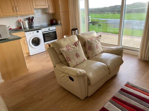 a living room with a couch in a kitchen at Cliff End Self catering bungalow with sea views in beautiful rural West Wight Free WiFi and ferry offers available Short walk to beach in Isle of Wight