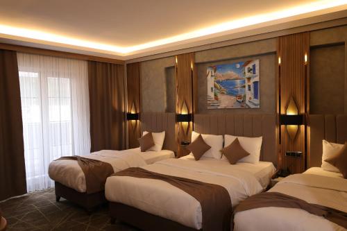 a hotel room with three beds in it at Mir Emir Hotel in Bostaniçi