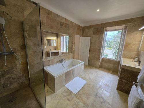 a large bathroom with a tub and a shower at Bastide du Luberon in Apt