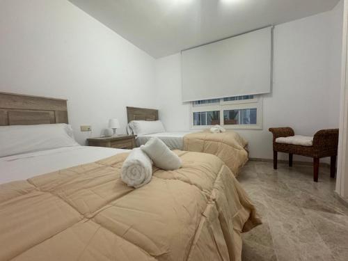 a bedroom with two beds with towels on them at Cozy Sunset in Almerimar