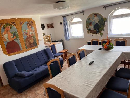a living room with a large table and a blue couch at Sklípek u Šťavíků Za Valama in Čejkovice