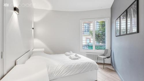 une chambre blanche avec un lit et une fenêtre dans l'établissement Le Segoffin, à Toulouse